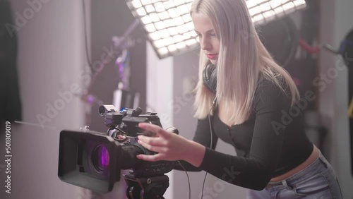 Confident cute woman filmmaker operate professional video camera on set 4K