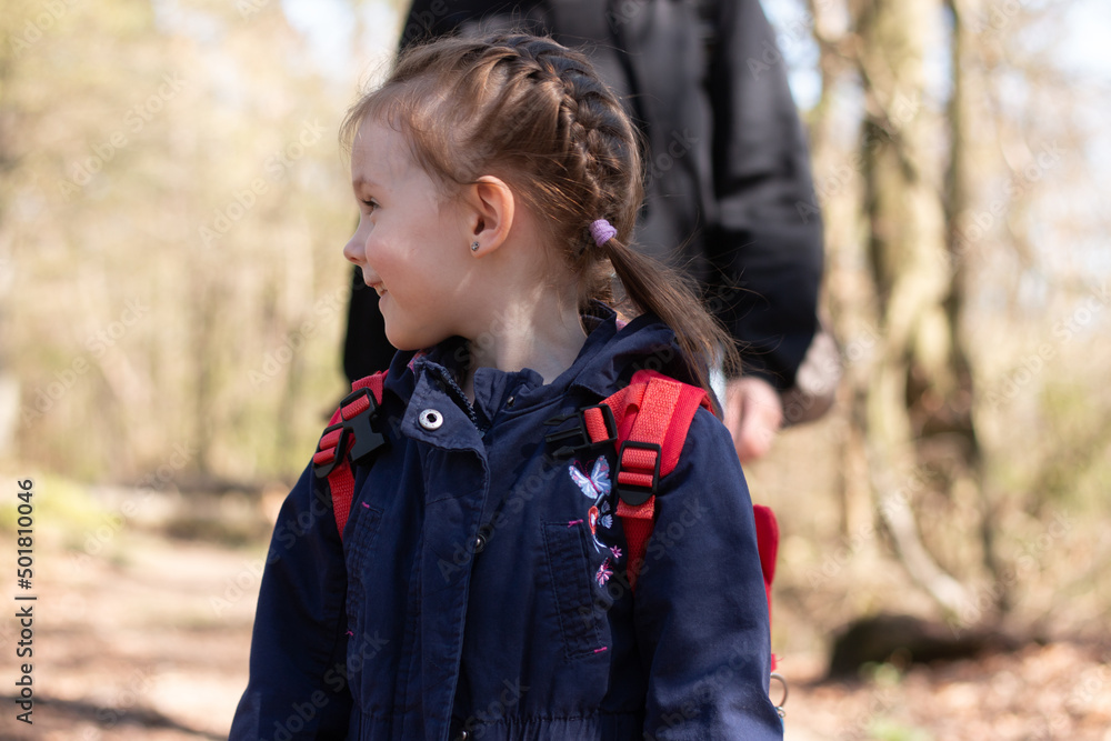 Little cheerful smiling girl looks away. Child on a walk in the park Little cheerful smiling girl looks away. Child on a walk in the park