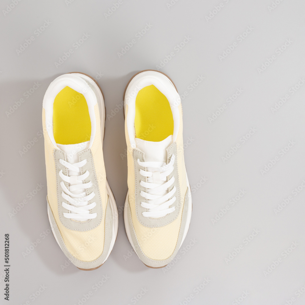 classic light color sneakers on grey background classic light color sneakers on grey background