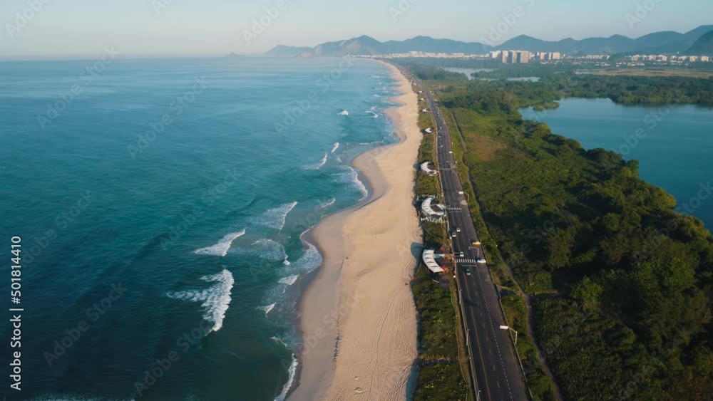 Aerial view of Reserva beach, Marapendi lagoon and car traffic on Lucio Costa avenue. Barra da Tijuca and Recreio, in Rio de Janeiro, Brazil. Sunrise. Sunny day. Drone take. Praia da Reserva. Aerial view of Reserva beach, Marapendi lagoon and car traffic on Lucio Costa avenue. Barra da Tijuca and Recreio, in Rio de Janeiro, Brazil. Sunrise. Sunny day. Drone take. Praia da Reserva.
