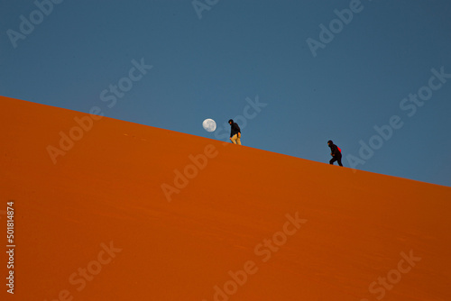 People walk on the dune in the Kalahari Desert, Namibia.