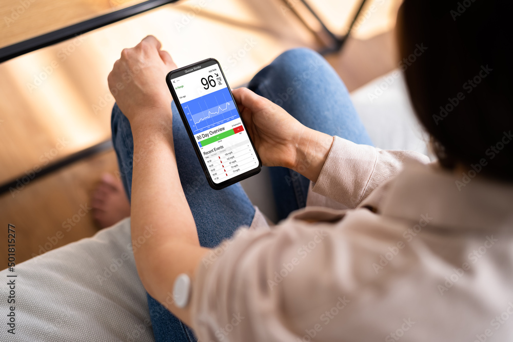 Woman Using Continuous Glucose Remote Monitor Diabetes Woman Using Continuous Glucose Remote Monitor Diabetes