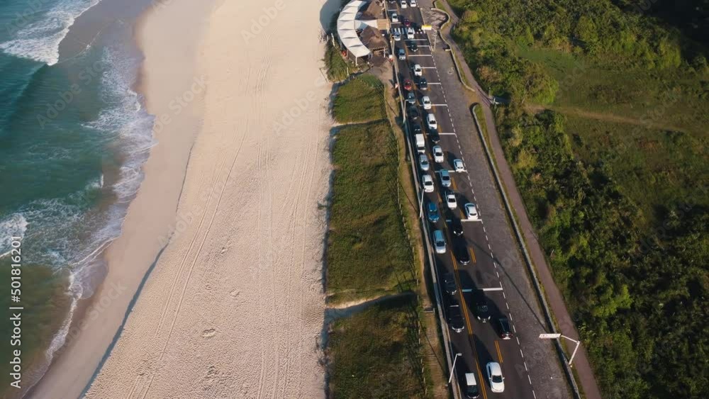 Aerial view of Reserva beach, Marapendi lagoon and car traffic on Lucio Costa avenue. Barra da Tijuca and Recreio, in Rio de Janeiro, Brazil. Sunrise. Sunny day. Drone take. Praia da Reserva. Aerial view of Reserva beach, Marapendi lagoon and car traffic on Lucio Costa avenue. Barra da Tijuca and Recreio, in Rio de Janeiro, Brazil. Sunrise. Sunny day. Drone take. Praia da Reserva.