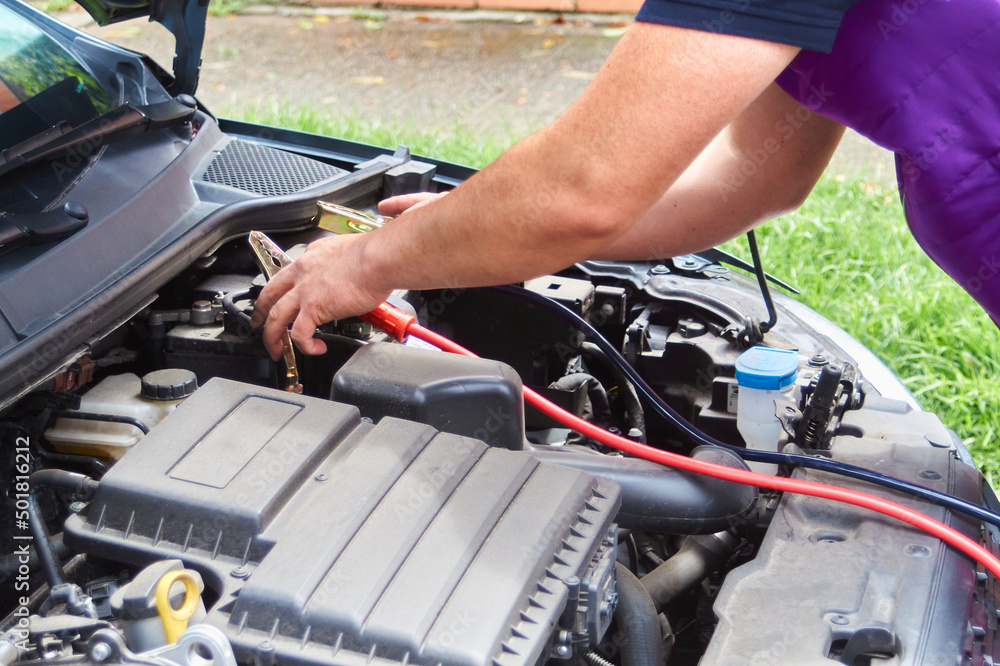 man resetting his vehicle's battery man resetting his vehicle's battery