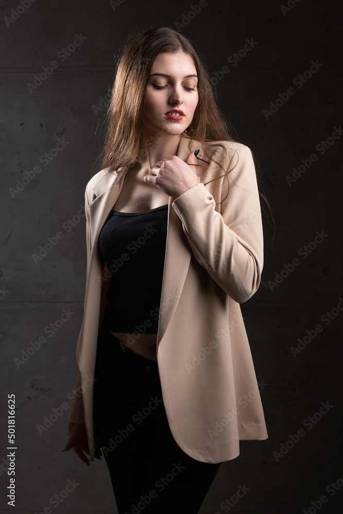 Portrait of a young brunette with long hair in the studio. Dramatic photo in dark colors. Portrait of a young brunette with long hair in the studio. Dramatic photo in dark colors.