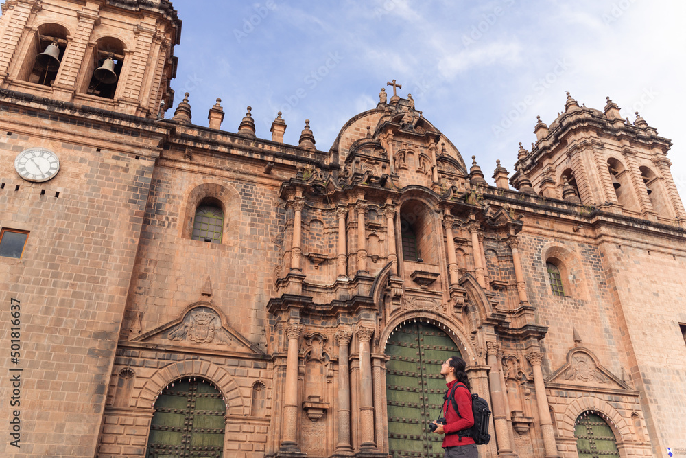 Tourist looking at the cathedral in the main square of Cuzco