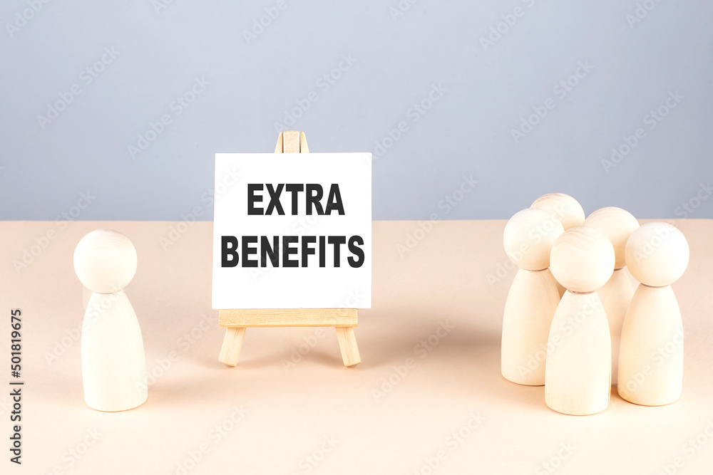 EXTRA BENEFITS text on easel with wooden figure, meeting concept EXTRA BENEFITS text on easel with wooden figure, meeting concept