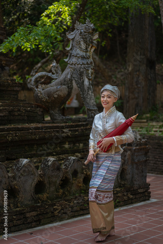 Beautiful Asian women dressed in traditional costumes visit Wat Palad or Wat Pha Lat temple ancient temples pray to the sacred according to Buddhist beliefs in Chiang Mai, Thailand. photo