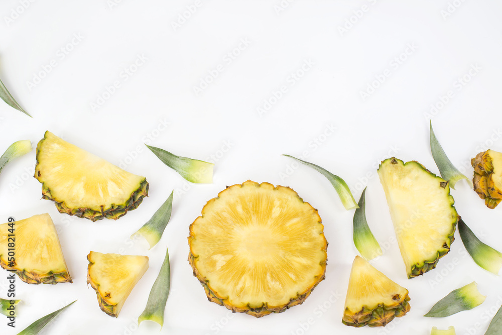 Sliced pineapple with green pineapple leaves isolated on white