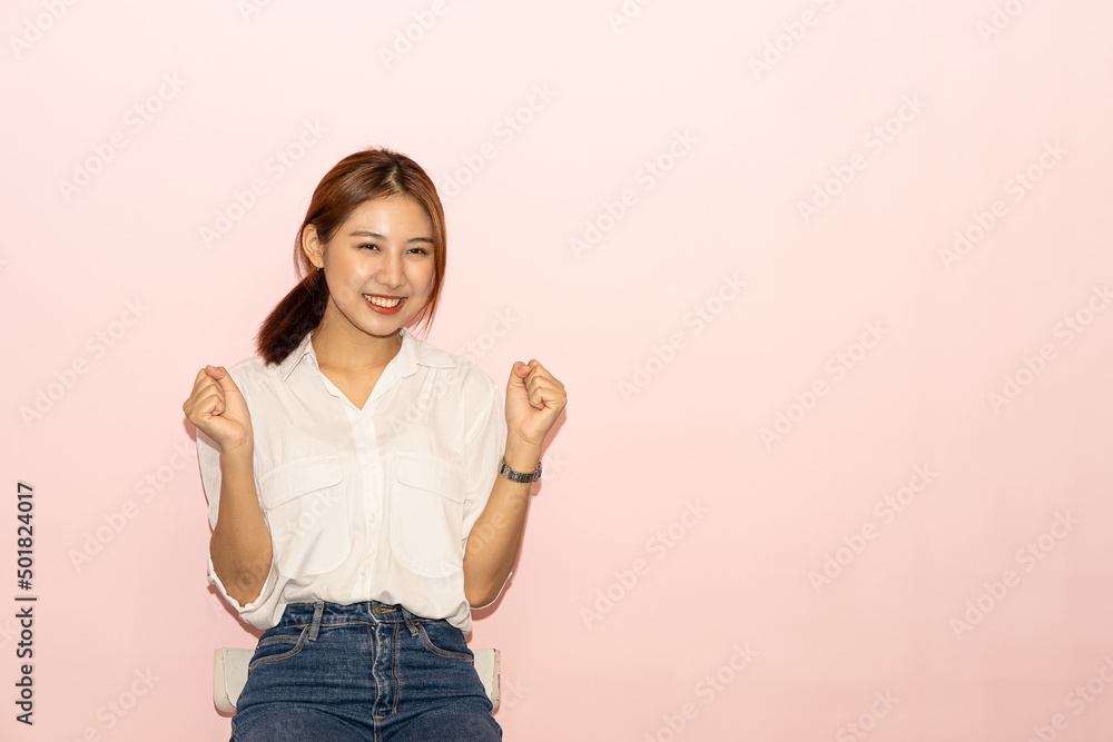 A portrait of a cute Asian beautiful woman with black hair in a white dress poses with a gentle smile. lonely on a pink background A portrait of a cute Asian beautiful woman with black hair in a white dress poses with a gentle smile. lonely on a pink background