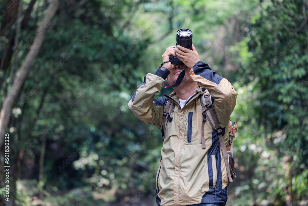 Young male professional photographer holding camera take photos outdoors park Young male professional photographer holding camera take photos outdoors park