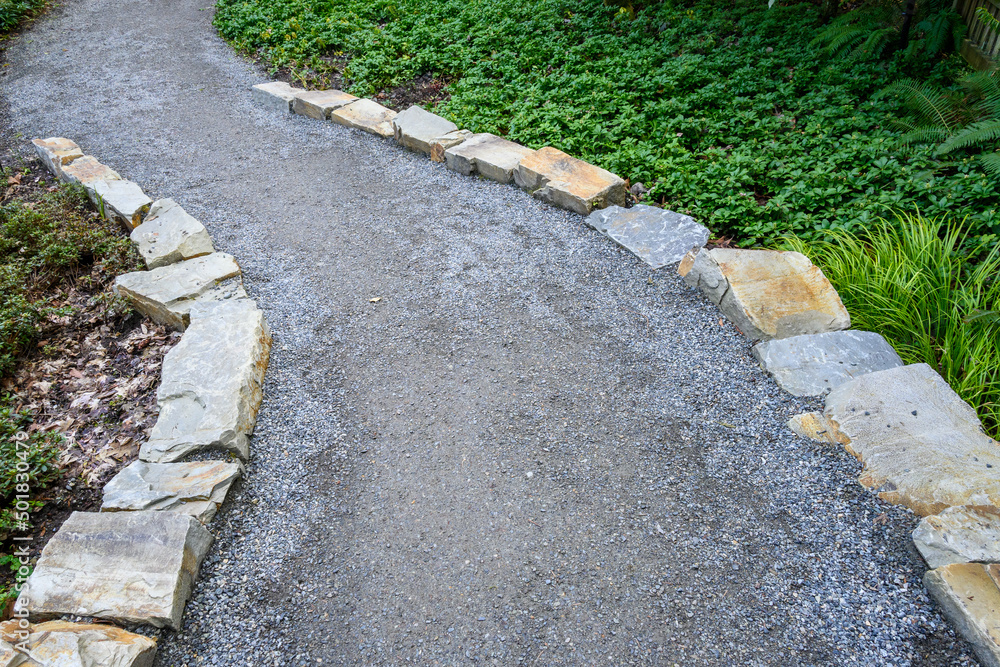 Gravel path lined by stone, an invitation to explore a woodland garden
Gravel path lined by stone, an invitation to explore a woodland garden