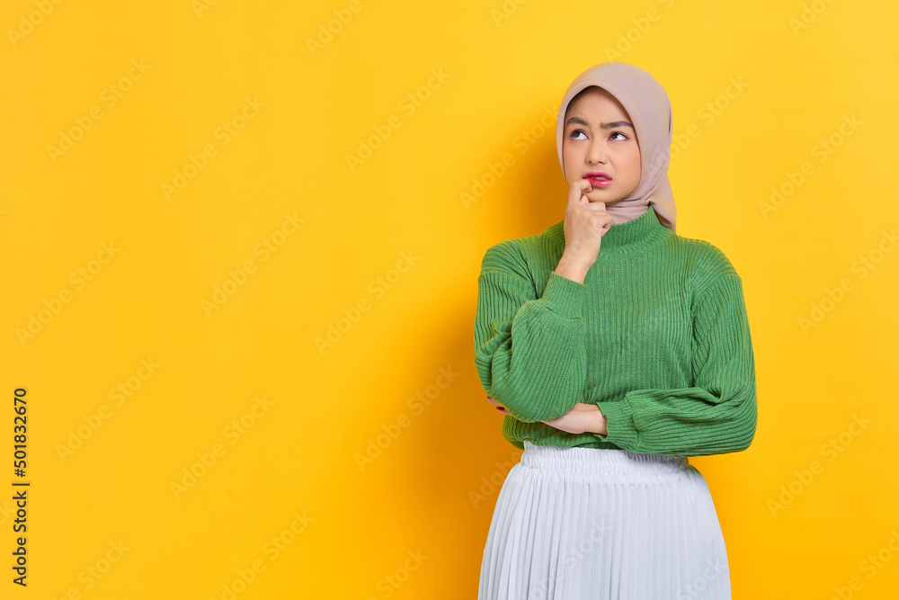 Pensive beautiful Asian woman in green sweater thinking about something and looking away isolated over white background Pensive beautiful Asian woman in green sweater thinking about something and looking away isolated over white background