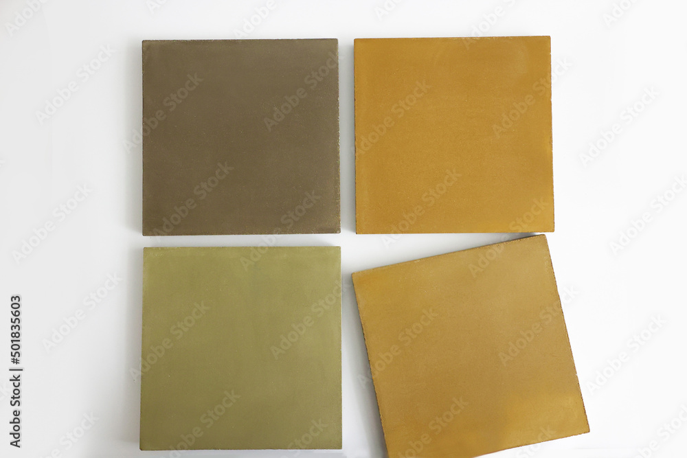 Fototapeta premium Layout of concrete tiles of square shape of autumn shades on the exhibition stand of the hardware store. Advertising of building materials for the creation of modern landscape designs