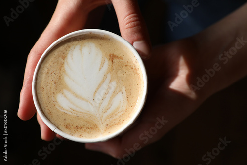 Barista prepares coffee in a paper cup