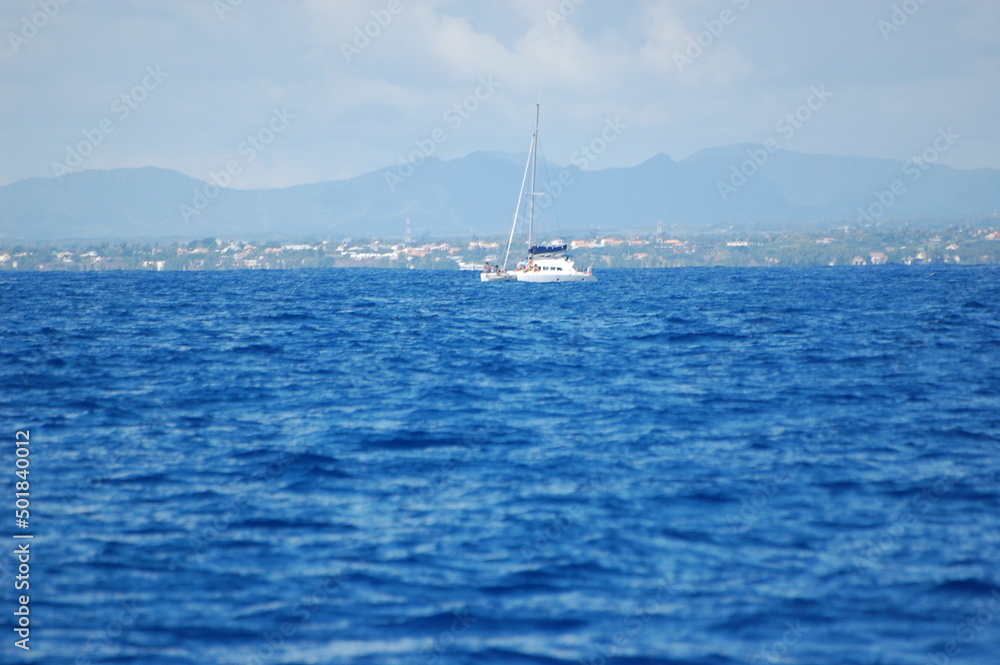 yacht with a white sail in the blue sea off the coast of mauritius