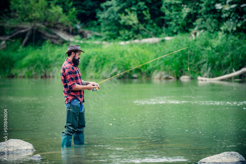 Man pulling fishing rod. Fisherman man on river or lake with fishing rod.