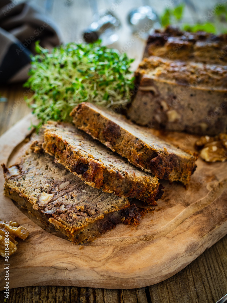 Tasty pate with walnuts on cutting board