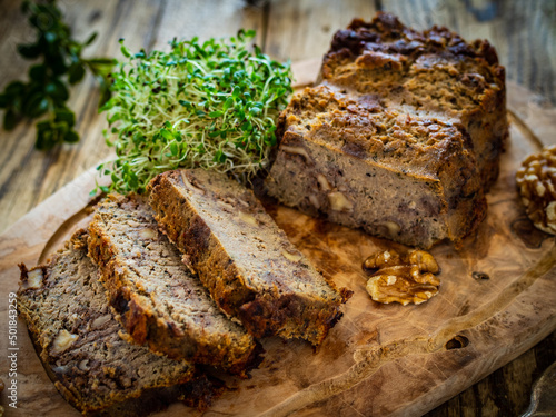 Tasty pate with walnuts on cutting board