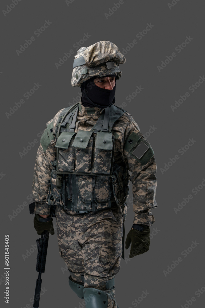 Portrait of soldier from ukraine with rifle dressed in uniform looking away isolated on gray background. Portrait of soldier from ukraine with rifle dressed in uniform looking away isolated on gray background.