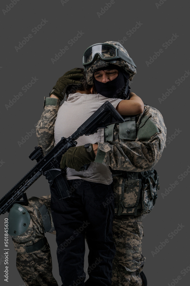Portrait of professional serviceman dressed in camouflage clothes hugging little boy. Portrait of professional serviceman dressed in camouflage clothes hugging little boy.