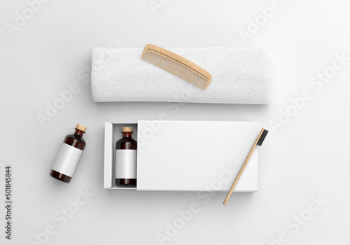 White blank Hotel Amenity Box with towel and wooden comb and toothbrush on a plain background. 