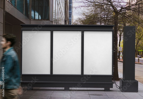 Three blank white empty vertical outdoor posters are displayed on the advertising public panel.  
