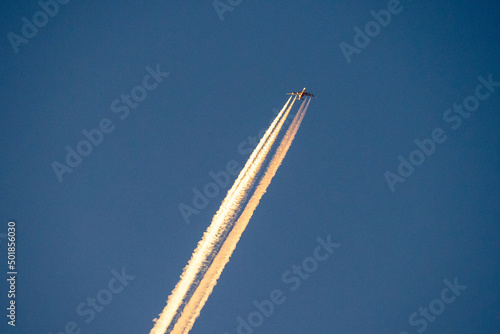 Telephoto shot of an Airliner at cruising altitude flying into the sunset.