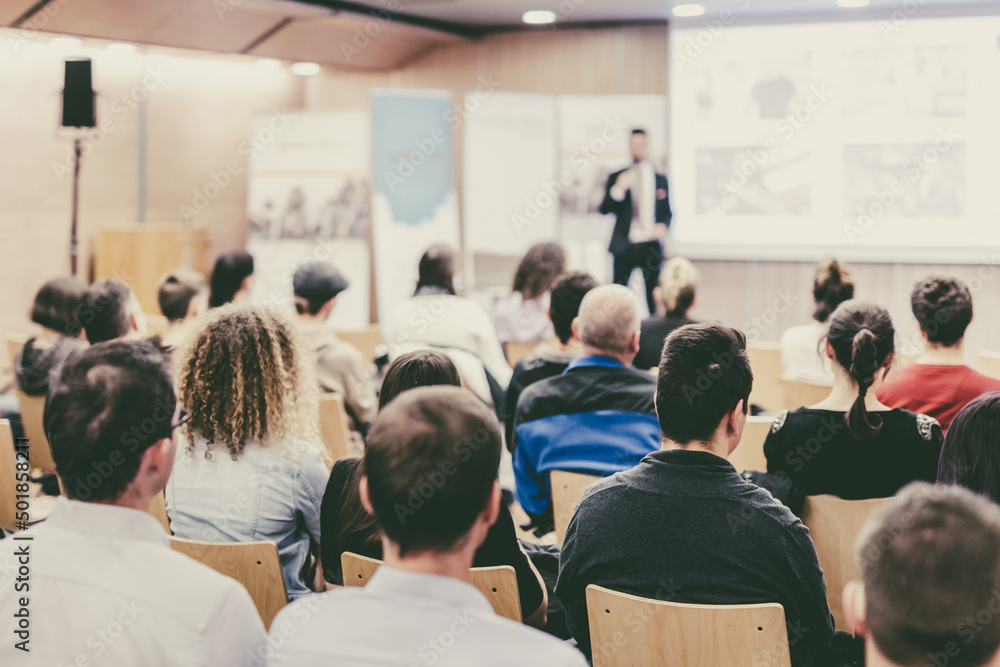 Business speaker giving a talk at business conference event.