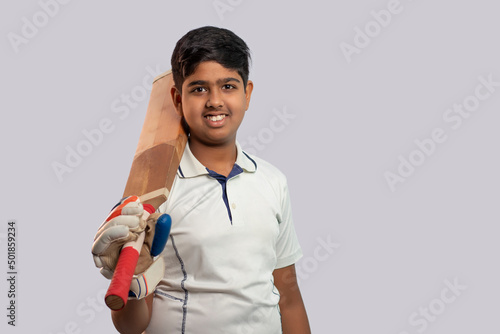 Photography A boy in cricket uniform holding Cricket Bat