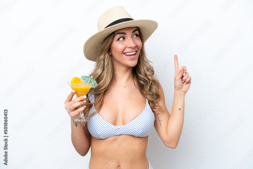 Young woman holding cocktail and wearing a bikini isolated on white background intending to realizes the solution while lifting a finger up Young woman holding cocktail and wearing a bikini isolated on white background intending to realizes the solution while lifting a finger up