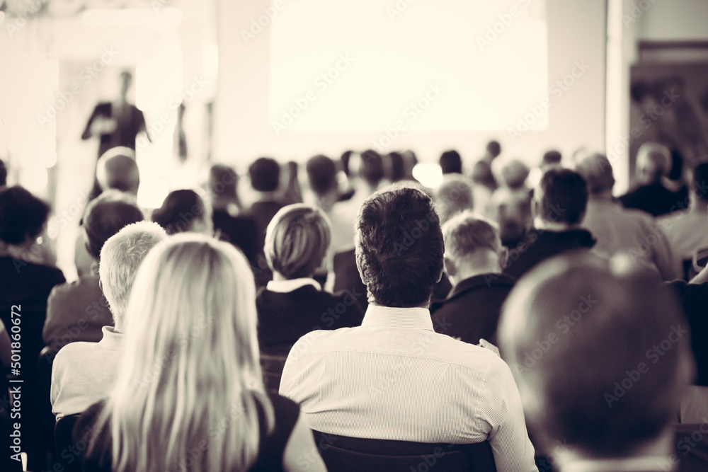 Obraz premium Speaker giving a talk in conference hall at business meeting event. Rear view of unrecognizable people in audience at the conference hall.