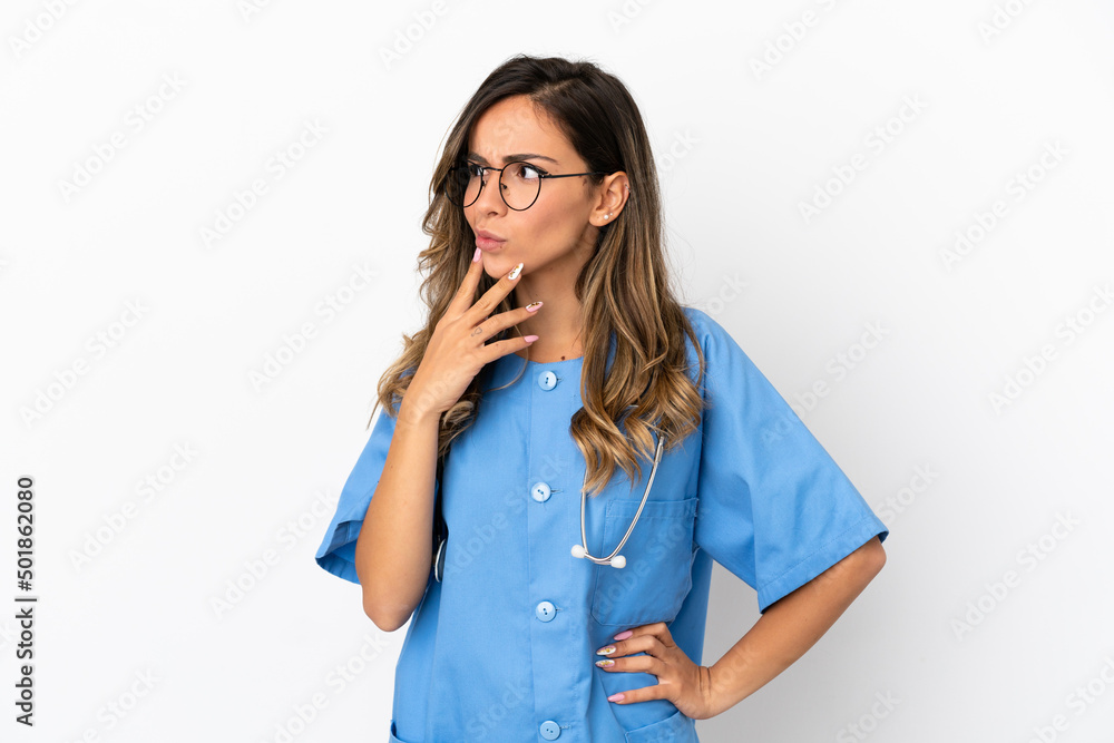 Young surgeon doctor woman over isolated white wall having doubts and with confuse face expression Young surgeon doctor woman over isolated white wall having doubts and with confuse face expression