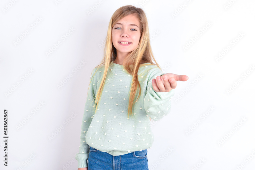 little caucasian kid girl wearing fashion sweater over blue background smiling cheerful offering palm hand giving assistance and acceptance. little caucasian kid girl wearing fashion sweater over blue background smiling cheerful offering palm hand giving assistance and acceptance.