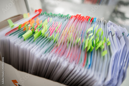 Stack of business report paper file on modern white office desk with bokeh background. photo