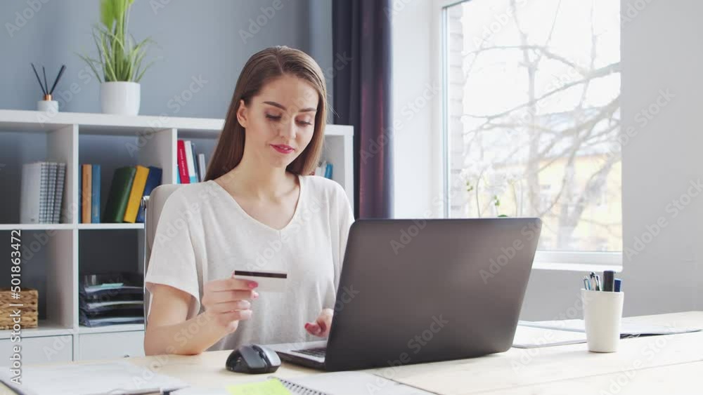 Young Woman Makes online Purchases on the Internet Using a Bank Credit Card. Workplace of Female Entrepreneur, Freelancer or Student. Payment Systems Concept. Young Woman Makes online Purchases on the Internet Using a Bank Credit Card. Workplace of Female Entrepreneur, Freelancer or Student. Payment Systems Concept.