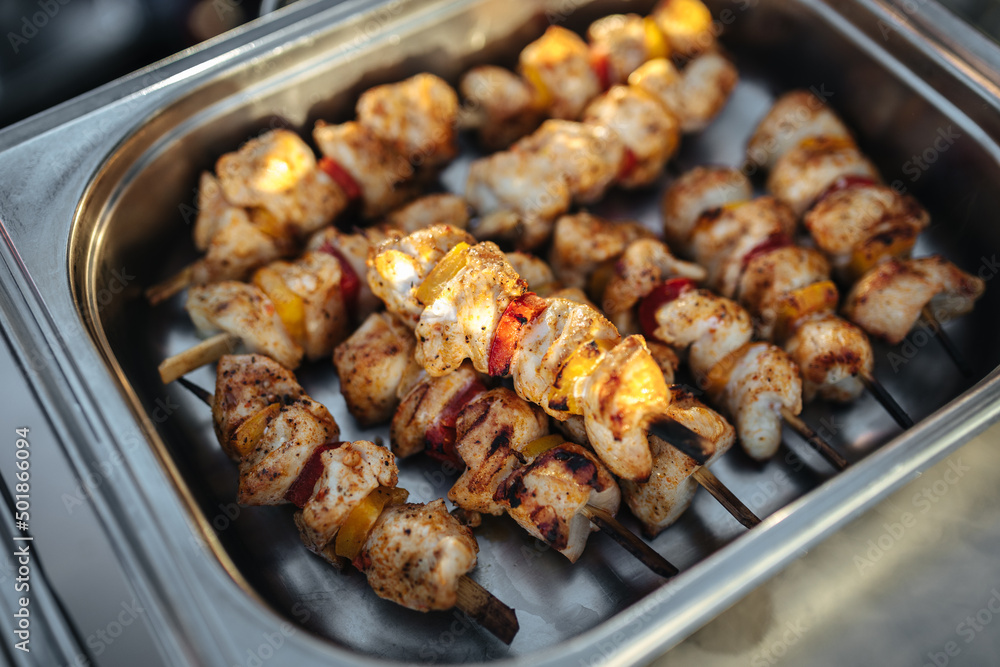 Shashlik meat skewers in a silver tray at a barbecue