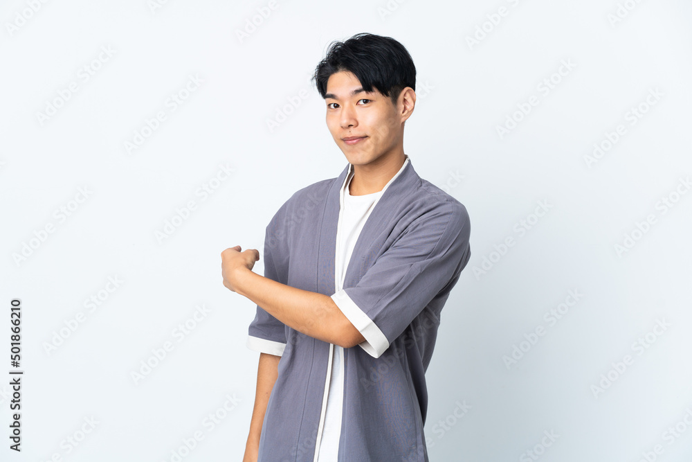 Young Chinese man isolated on white background pointing back Young Chinese man isolated on white background pointing back