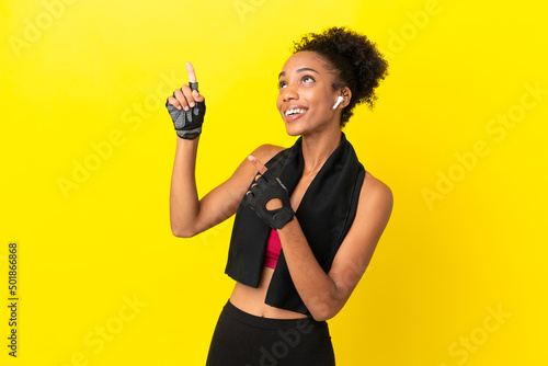 Young African sport woman isolated on yellow background pointing with the index finger a great idea