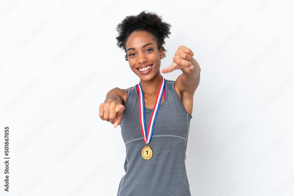 Young African American woman with medals isolated on white background points finger at you while smiling Young African American woman with medals isolated on white background points finger at you while smiling