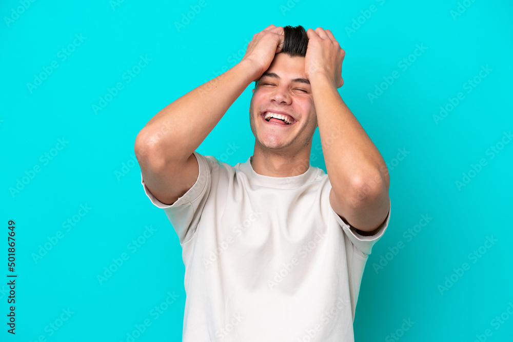 Naklejka premium Young handsome caucasian man isolated on blue bakcground laughing
