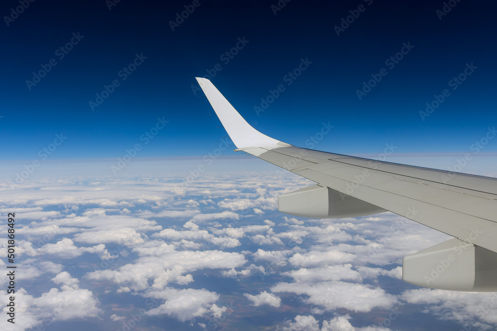Wing aircraft on clouds blue sky with flying view from airplane window Wing aircraft on clouds blue sky with flying view from airplane window