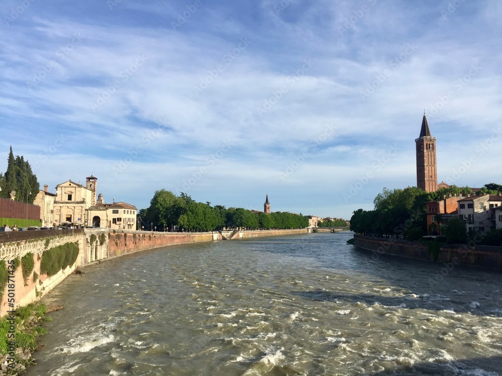 Obraz premium Adige river view from Ponte Pietra. Tower bell of Saint Anastasia church and facades of medieval buildings. Selective focus. Verona, Italy