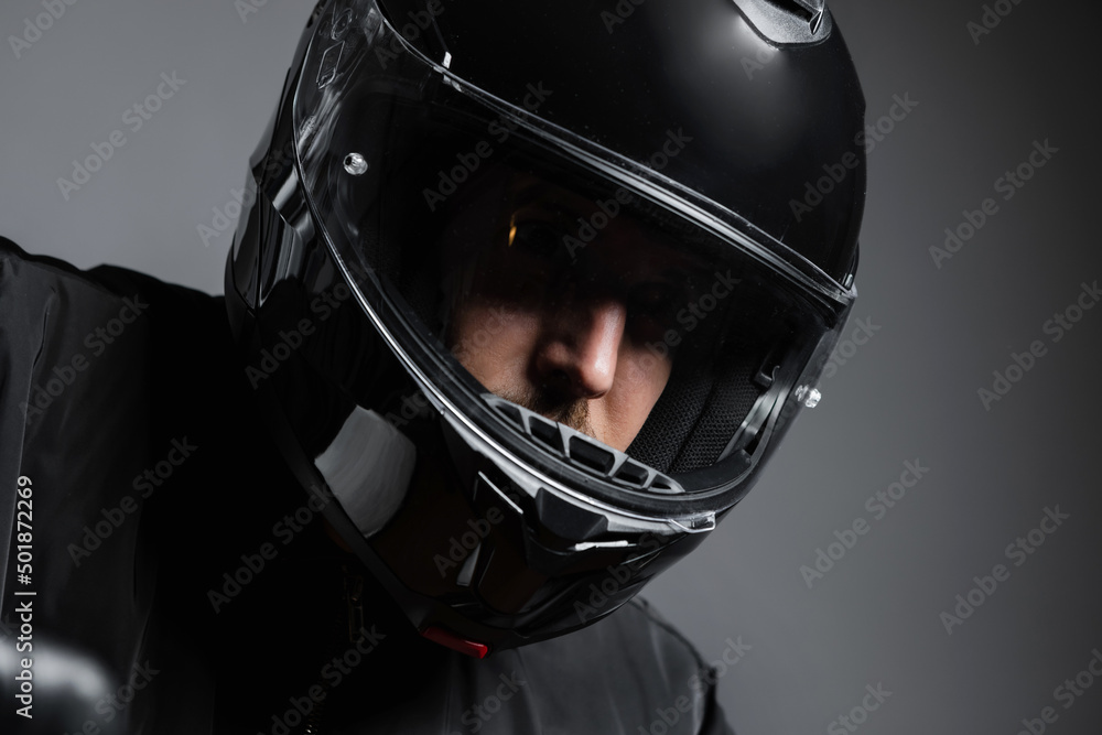 Fototapeta premium Biker in the helmet close up portrait, riding motorcycle, studio shot