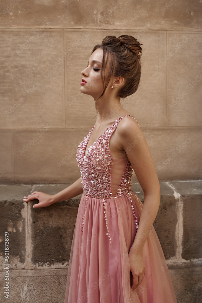 Portrait of beauiful European girl bridesmaid in classic pink dress
