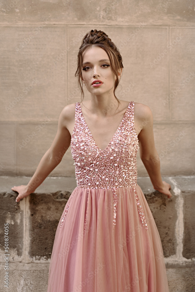 Portrait of beauiful European girl bridesmaid in classic pink dress