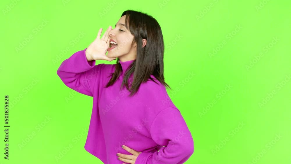 Young brunette woman shouting to the lateral and announcing something over isolated background. Green screen chroma key Young brunette woman shouting to the lateral and announcing something over isolated background. Green screen chroma key