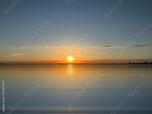 sunset at Baltic sea sun beam and light reflection on water background travel to Estonia