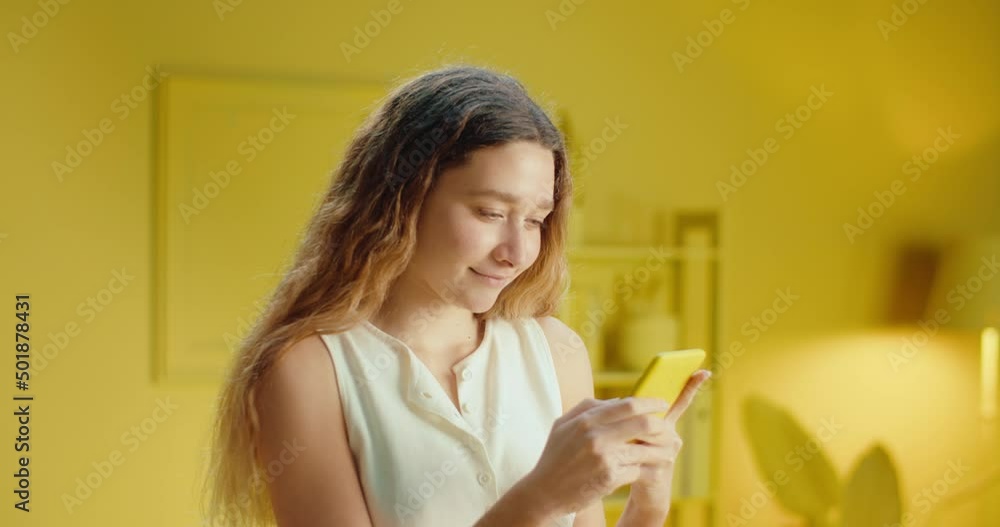 Close up portrait of positive cheerful girl using a smartphone and read social network chat enjoy online communication. Pretty fashionable woman using mobile phone, typing sms message in studio Close up portrait of positive cheerful girl using a smartphone and read social network chat enjoy online communication. Pretty fashionable woman using mobile phone, typing sms message in studio