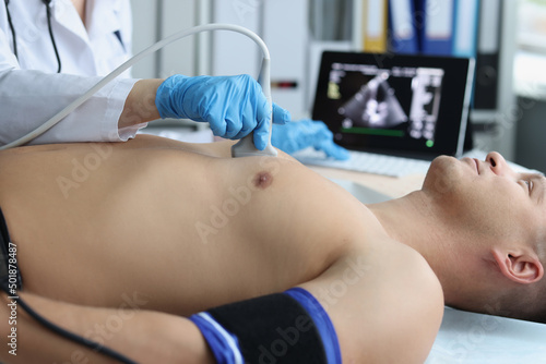 Canvas Print Doctor doing ultrasound of rib cage, cardiologist examining a patients heart